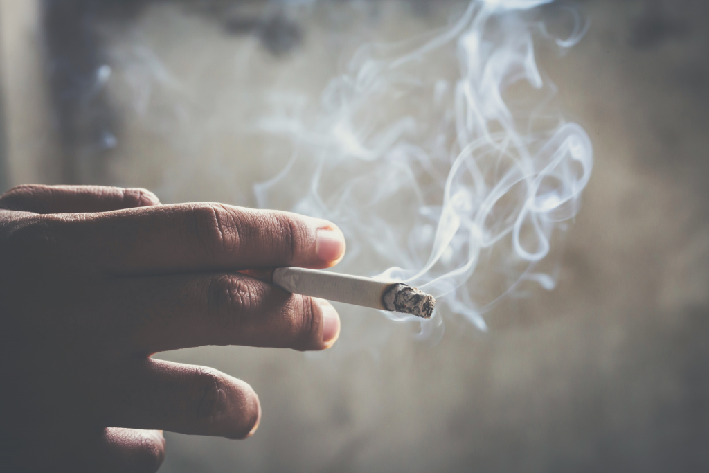 Una persona cogiendo un cigarrillo que nos ayuda a explicar los efectos del tabaco en la circulación