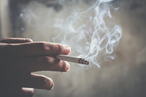 Una persona cogiendo un cigarrillo que nos ayuda a explicar los efectos del tabaco en la circulación